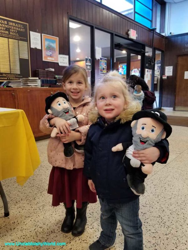 Two Uncle Moishy fans holding their Uncle Moishy dolls.