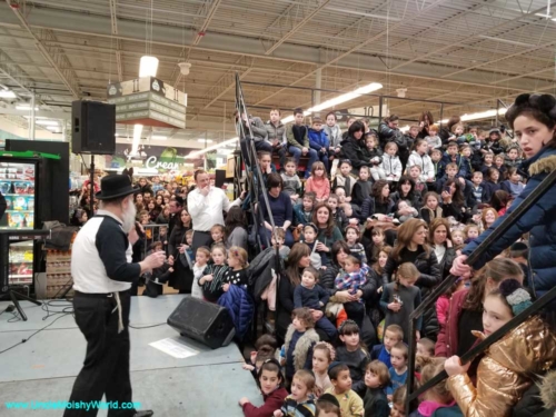 Performing to a large Jewish children's audience, Uncle Moishy performing on stage.