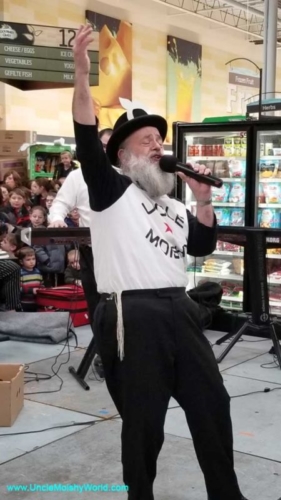 Moishy Tanenbaum, the renowned Uncle Moishy singing passionately at the Gourmet Glatt in Lakewood.